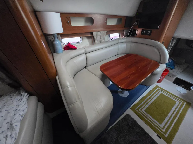 Slide: The Image of 2003 Four Winns 328 Vista interior with beige seating and wooden table. - 30