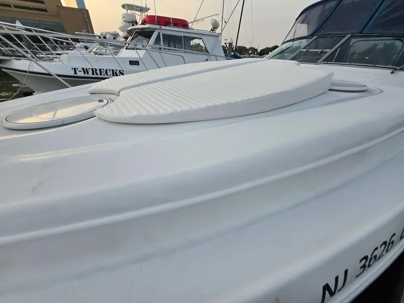 Slide: The Image of 2003 Four Winns 328 Vista boat docked, featuring sleek white deck design. - 34