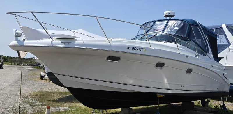 Slide: The Image of 2003 Four Winns 328 Vista boat on land, white hull, blue canopy, side view. - 37
