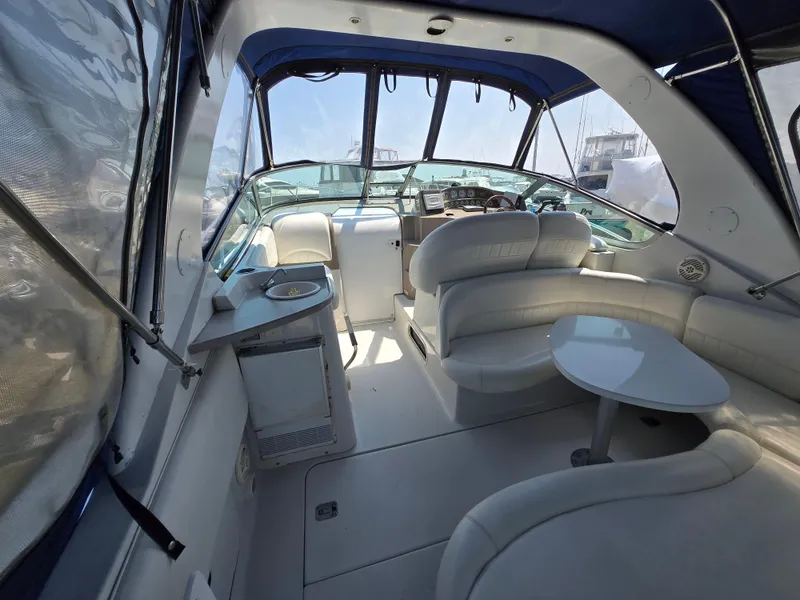Slide: The Image of 2003 Four Winns 328 Vista boat interior with seating and helm, featuring blue canopy. - 42
