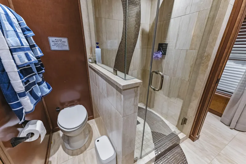 Slide: The Image of Modern bathroom with glass shower, toilet, and blue towels in a 2009 Sharpe model. - 18