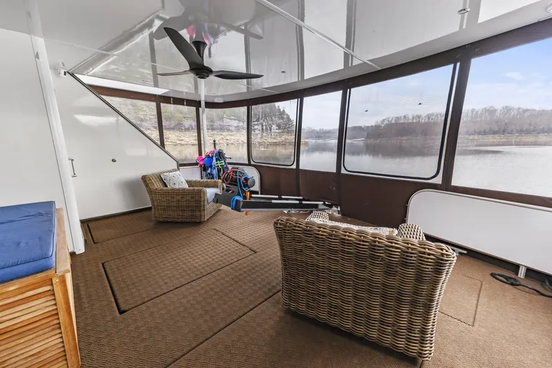 Slide: The Image of Houseboat interior with wicker chairs, large windows, and scenic river view. - 26