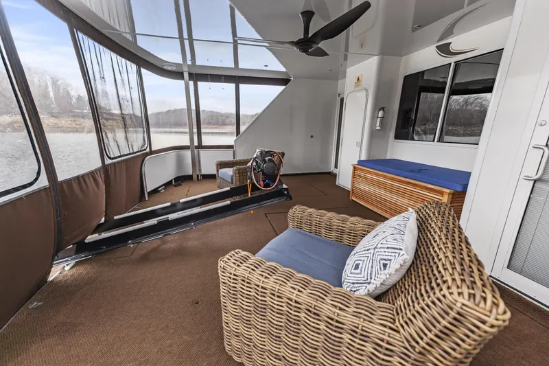 Slide: The Image of Spacious houseboat interior with wicker furniture, treadmill, and large windows overlooking water. - 28