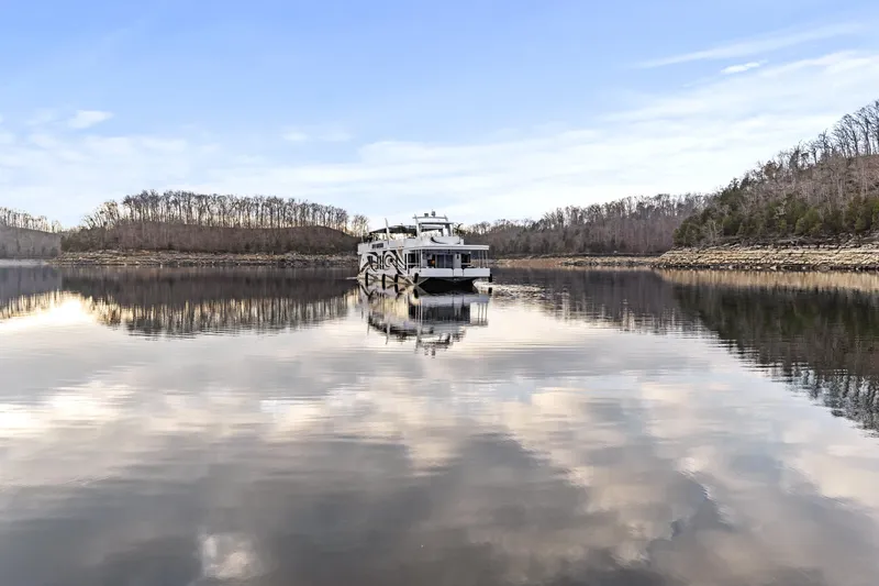 Slide: The Image of Houseboat on serene lake with cloudy sky reflection, surrounded by winter trees. - 45