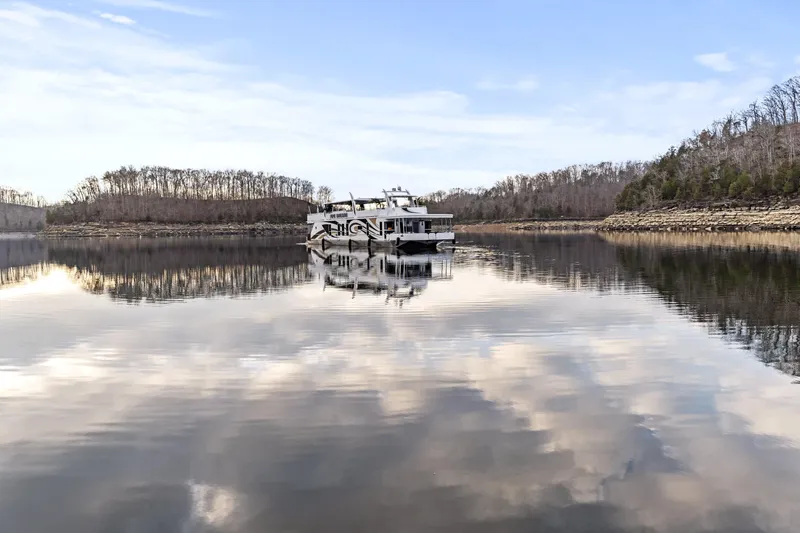 Slide: The Image of Houseboat on calm lake with cloudy sky reflection, surrounded by winter trees. - 48
