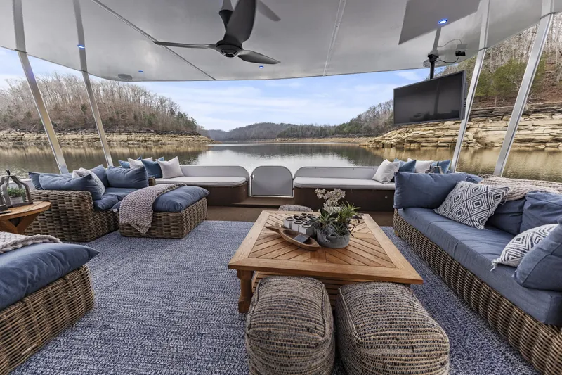 Slide: The Image of Luxurious houseboat interior with cozy seating, large TV, and scenic lake view. Sharpe 20 x 100, 2009. - 8