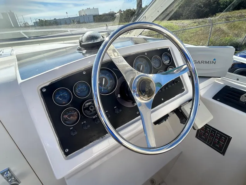 Slide: The Image of 1988 Bertram 28 Moppie boat dashboard with steering wheel and gauges. - 12