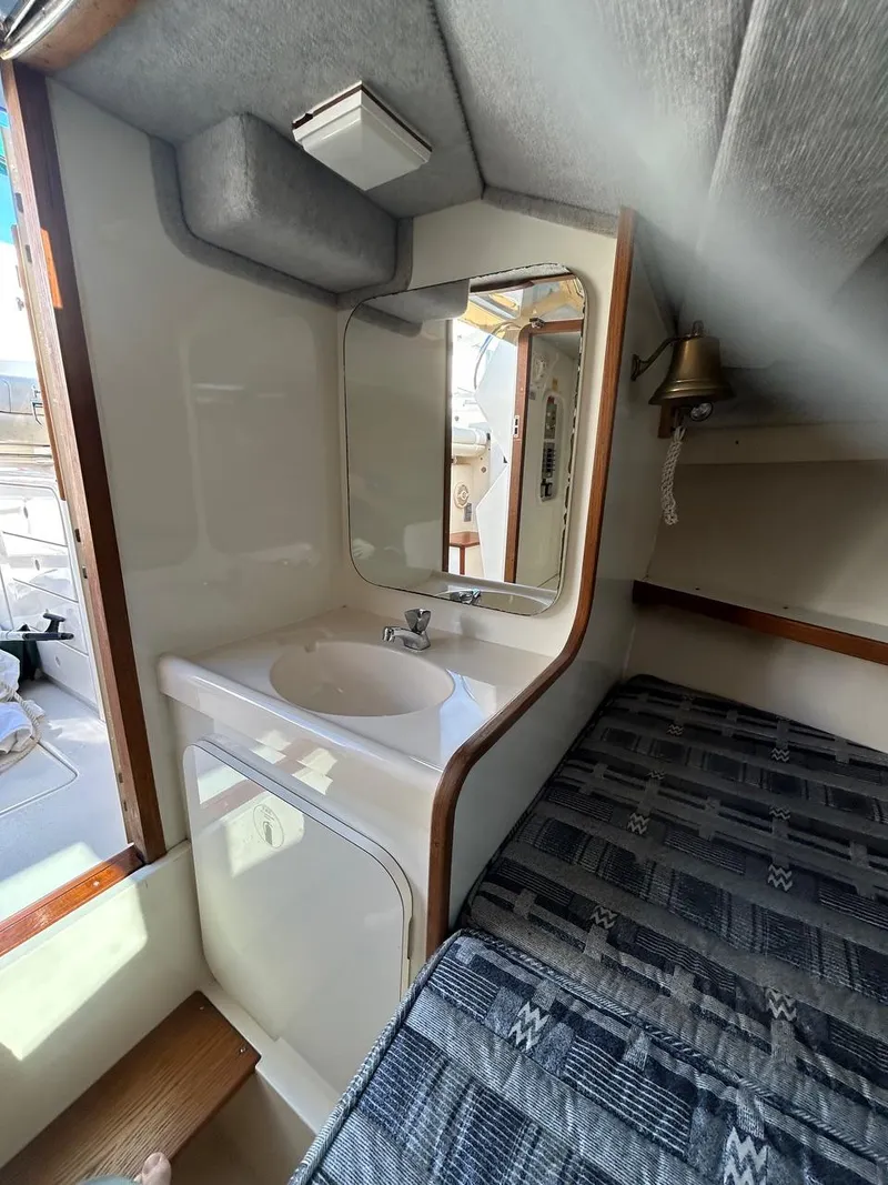 Slide: The Image of 1988 Bertram 28 Moppie cabin interior with sink, mirror, and bed. - 16