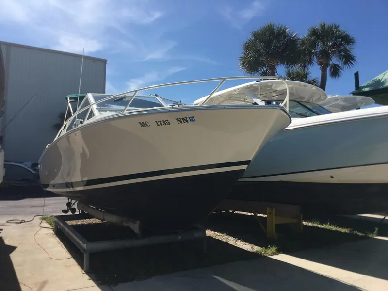 Slide: The Image of 1988 Bertram 28 Moppie boat on display under clear blue sky. - 2