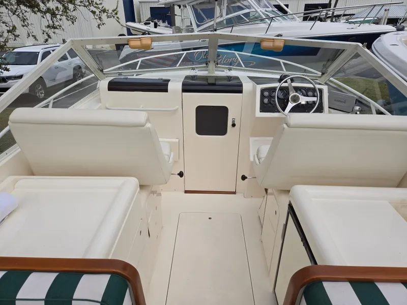 Slide: The Image of 1988 Bertram 28 Moppie boat interior with white seating and steering wheel. - 27