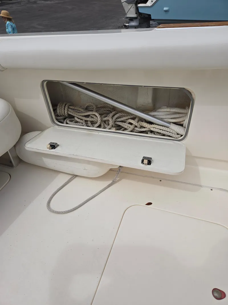 Slide: The Image of 1988 Bertram 28 Moppie boat with open storage compartment containing coiled ropes. - 29