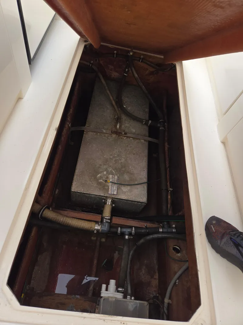 Slide: The Image of 1988 Bertram 28 Moppie engine compartment with visible fuel tank and hoses. - 30