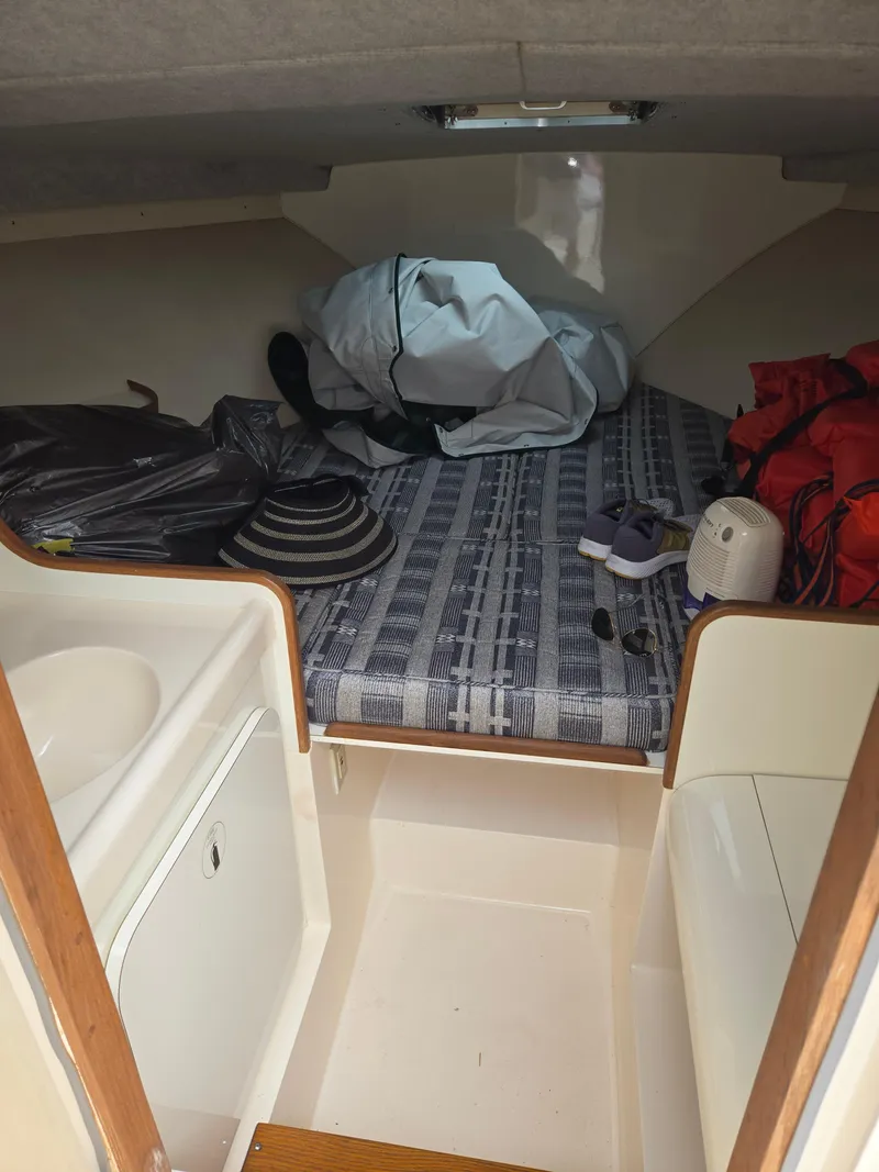 Slide: The Image of 1988 Bertram 28 Moppie cabin interior with bed, storage, and life jackets. - 31