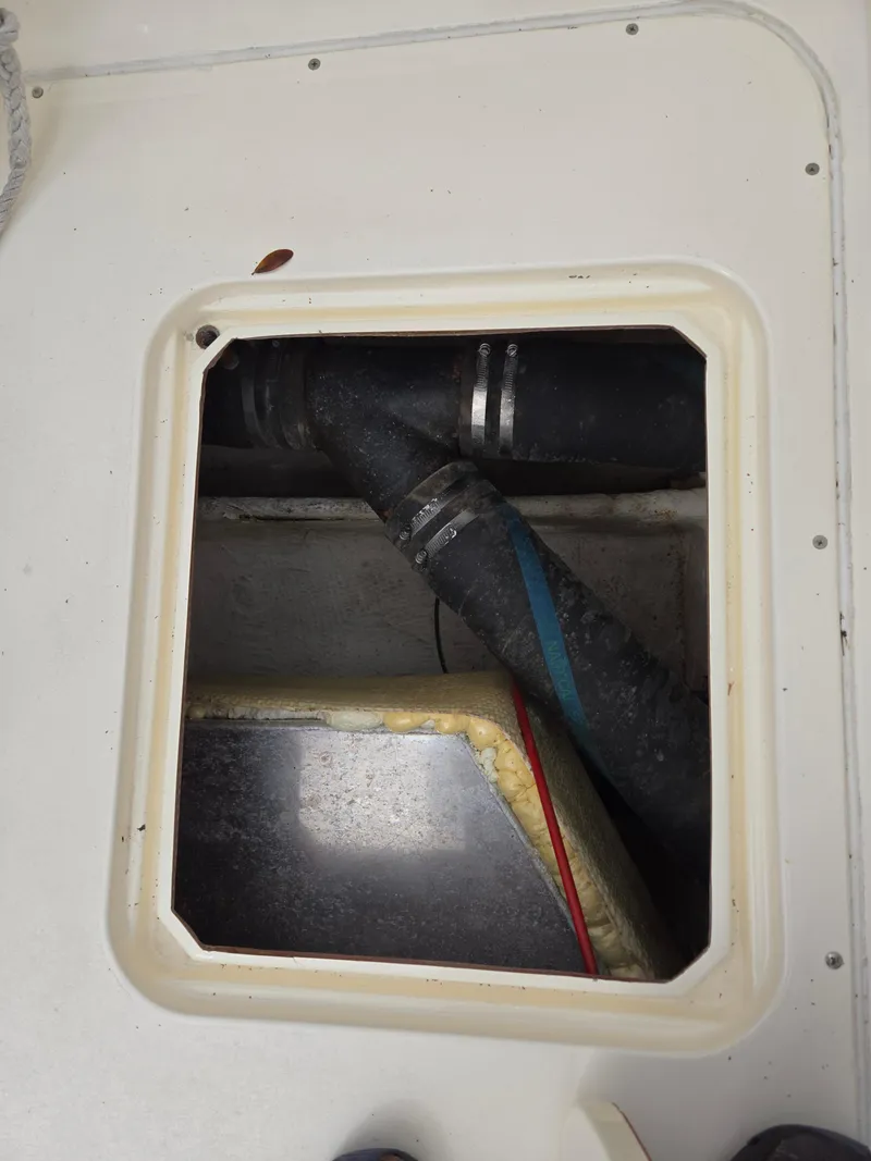Slide: The Image of Open hatch on 1988 Bertram 28 Moppie showing internal components and hoses. - 32
