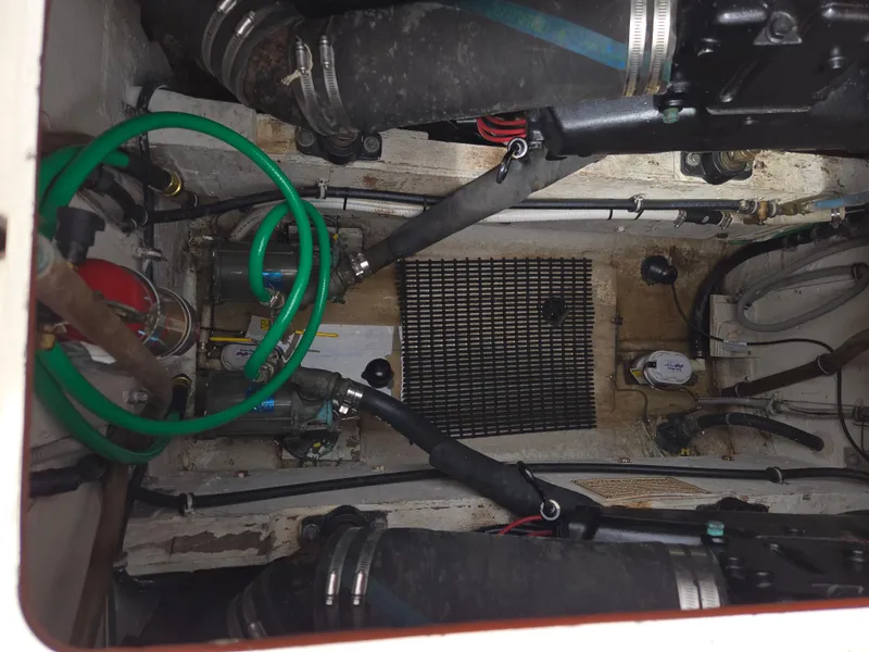 Slide: The Image of Engine compartment of a 1988 Bertram 28 Moppie boat, showing hoses and mechanical components. - 34