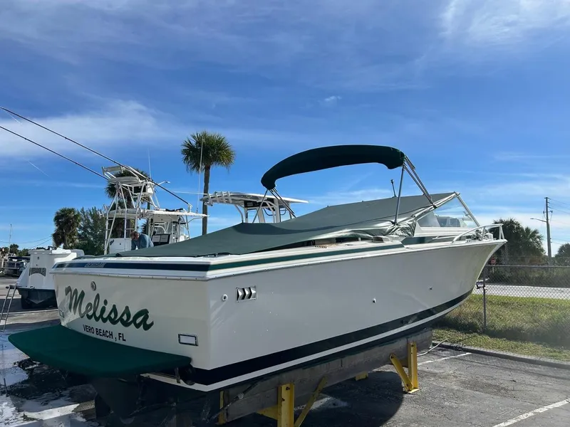 Slide: The Image of 1988 Bertram 28 Moppie boat named Melissa, docked under a clear blue sky. - 6