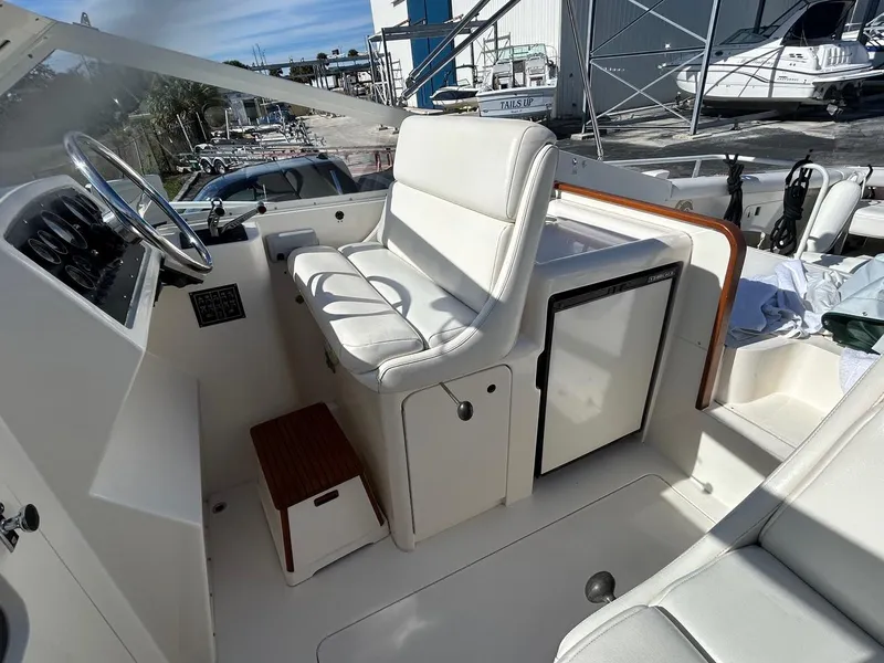 Slide: The Image of 1988 Bertram 28 Moppie boat interior with white seating and steering wheel. - 8