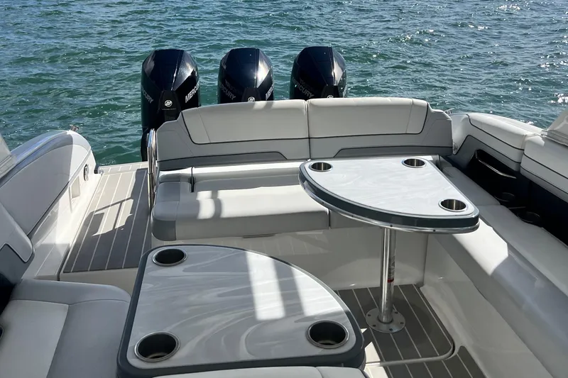 Slide: The Image of 2023 Formula 330 CBR boat interior with seating and tables on the water. - 8