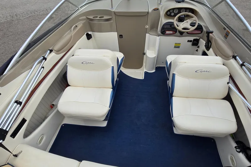 Slide: The Image of 2001 Bayliner 23 Capri boat interior with white seating and blue carpet. - 10
