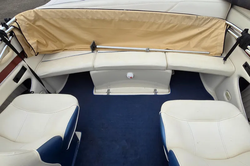 Slide: The Image of 2001 Bayliner 23 Capri boat interior with white seating and blue carpet. - 4