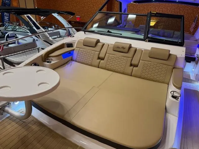 Slide: The Image of 2024 Sea Ray Sundancer 320 boat interior with beige seating and table. - 10