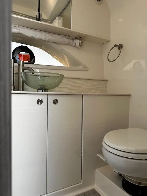 Slide: The Image of 2024 Sea Ray Sundancer 320 bathroom with modern sink and toilet. - 13