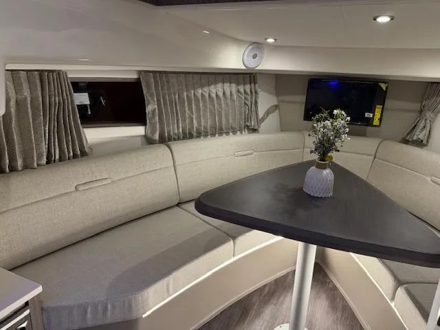 Slide: The Image of 2024 Sea Ray Sundancer 320 interior with elegant seating and table arrangement. - 16