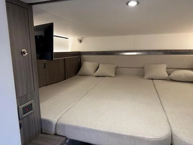 Slide: The Image of 2024 Sea Ray Sundancer 320 cabin interior with cozy bed and modern design. - 18