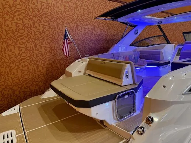 Slide: The Image of 2024 Sea Ray Sundancer 320 yacht with elegant interior lighting and American flag. - 2