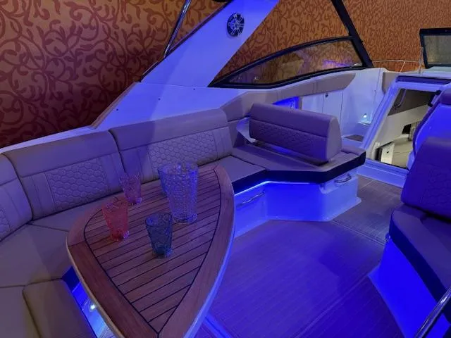 Slide: The Image of 2024 Sea Ray Sundancer 320 interior with elegant seating and ambient blue lighting. - 5