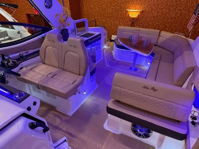 Slide: The Image of 2024 Sea Ray Sundancer 320 interior with luxurious seating and ambient lighting. - 9