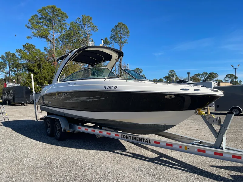 Slide: The Image of 2007 Chaparral 256 SSi boat on trailer, parked outdoors under clear blue sky. - 2