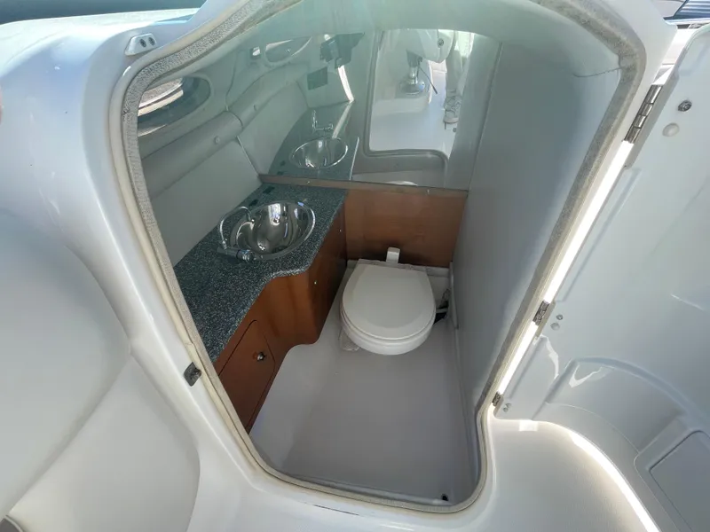 Slide: The Image of 2007 Chaparral 256 SSi boat interior with compact bathroom and sink. - 25
