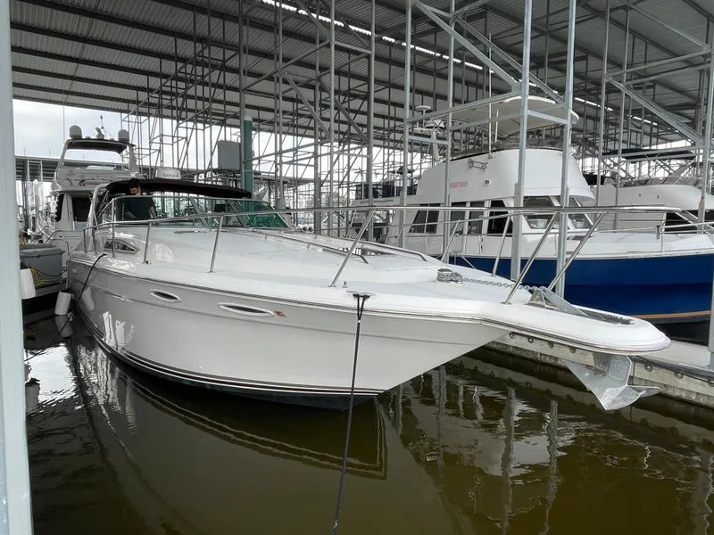 Slide: The Image of 1993 Sea Ray 370 Sundancer docked in a marina under a covered structure. - 2