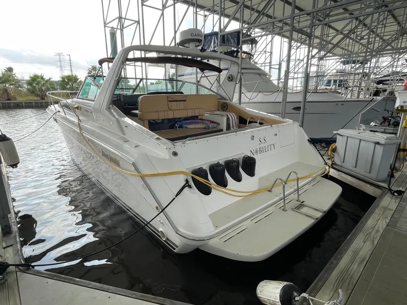 Slide: The Image of 1993 Sea Ray 370 Sundancer docked in a marina, showcasing sleek design and spacious deck. - 6