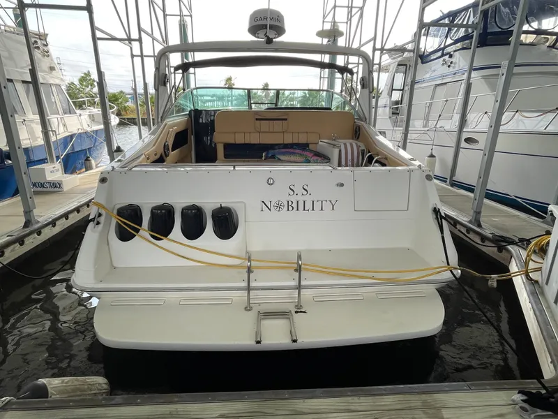 Slide: The Image of 1993 Sea Ray 370 Sundancer docked, rear view, named "S.S. Nobility". - 1