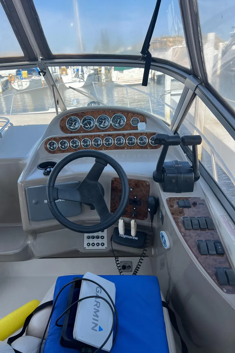 Slide: The Image of 1998 Regal 292 Commodore boat dashboard with steering wheel and control panel. - 11
