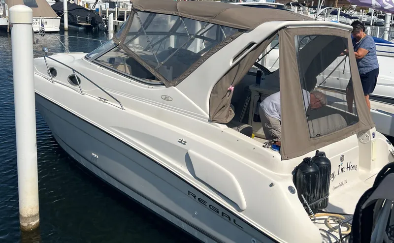 Slide: The Image of 1998 Regal 292 Commodore boat docked at marina with beige canopy. - 6