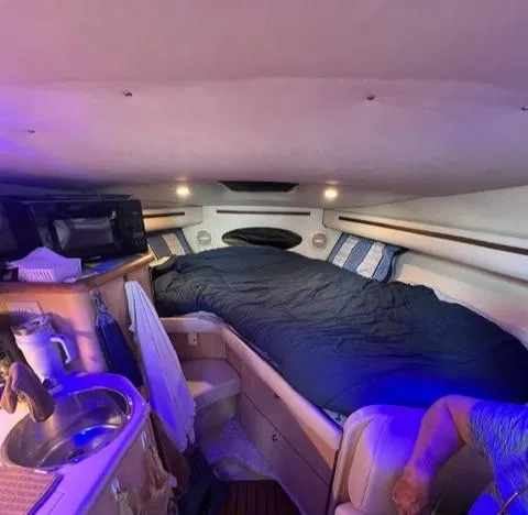 Slide: The Image of Interior of 1998 Regal 292 Commodore boat with cozy sleeping area and kitchenette. - 7