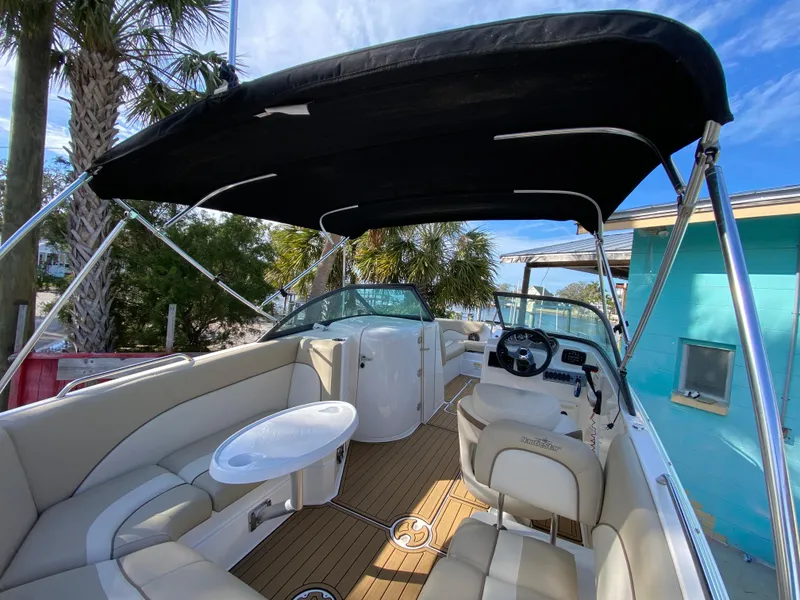 Slide: The Image of 2022 NauticStar 223 DC boat interior with canopy, seating, and steering wheel. - 17