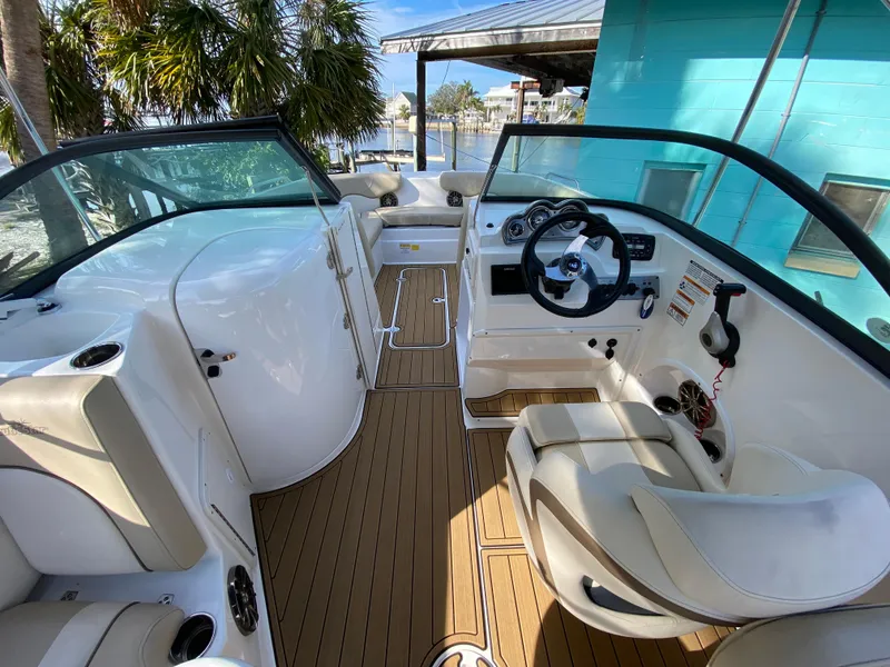 Slide: The Image of 2022 NauticStar 223 DC boat interior with white seating and wood-style flooring. - 22