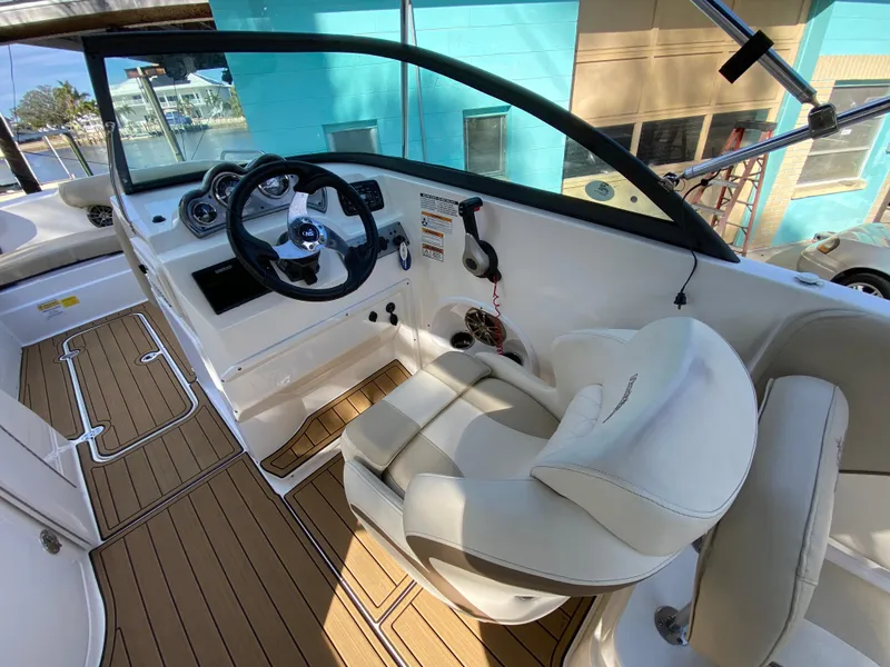 Slide: The Image of 2022 NauticStar 223 DC boat interior with steering wheel and cushioned seating. - 23
