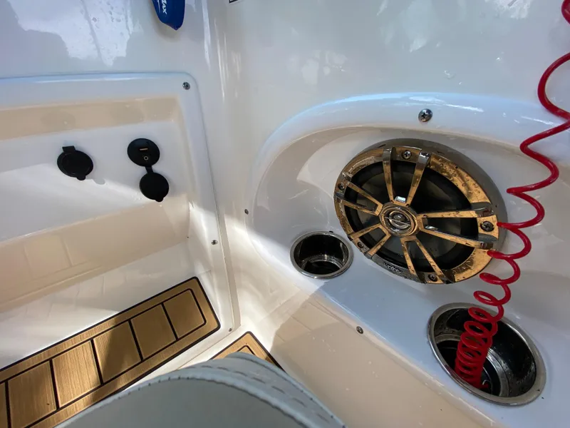 Slide: The Image of 2022 NauticStar 223 DC boat interior with speaker and cup holder. - 28