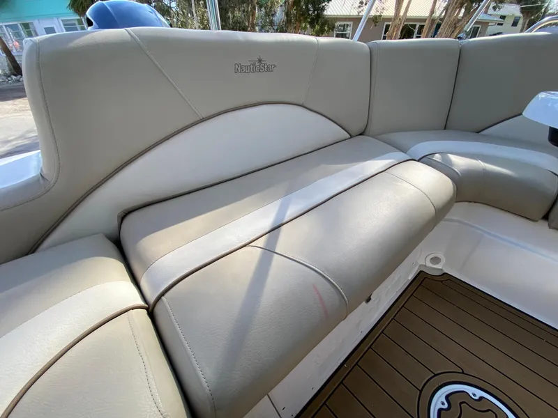 Slide: The Image of 2022 NauticStar 223 DC boat interior with beige cushioned seating. - 29