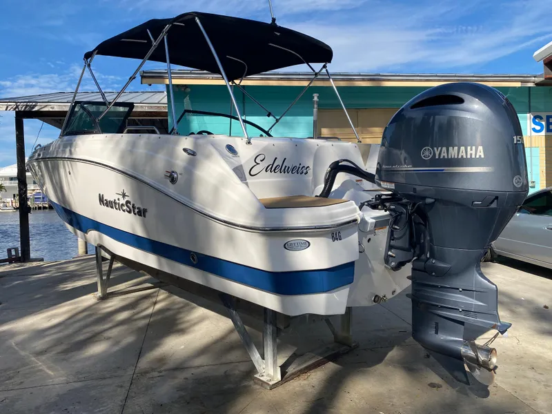 Slide: The Image of 2022 NauticStar 223 DC boat with Yamaha engine, docked under blue sky. - 3