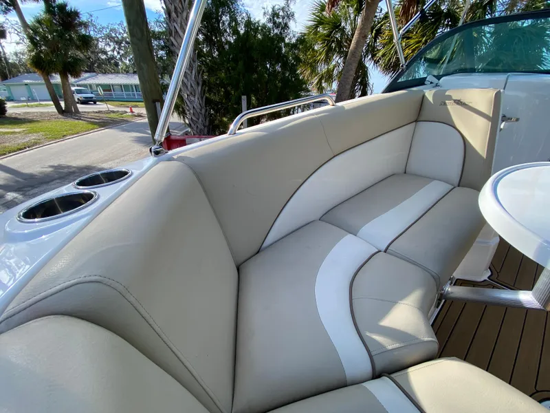 Slide: The Image of 2022 NauticStar 223 DC boat interior with beige seating and cup holders. - 30