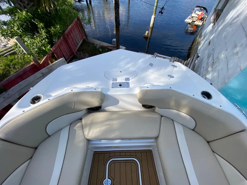 Slide: The Image of 2022 NauticStar 223 DC boat with beige seating, docked by a waterfront. - 37