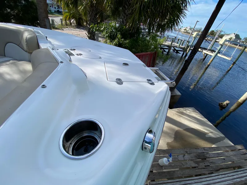 Slide: The Image of 2022 NauticStar 223 DC boat docked by a scenic waterfront. - 38