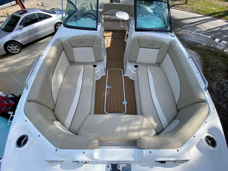 Slide: The Image of 2022 NauticStar 223 DC boat interior with beige seating and wood flooring. - 44