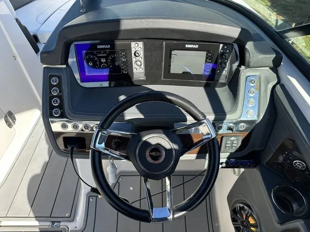 Slide: The Image of 2022 Chaparral 287 SSX boat dashboard with dual Simrad displays and modern steering wheel. - 24